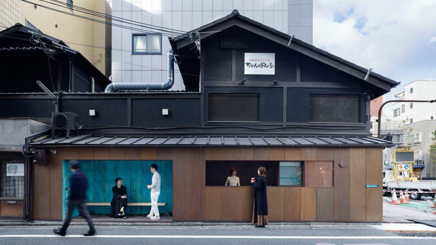 Copper-clad coffee kiosk attached to a black building by G Architects Studio