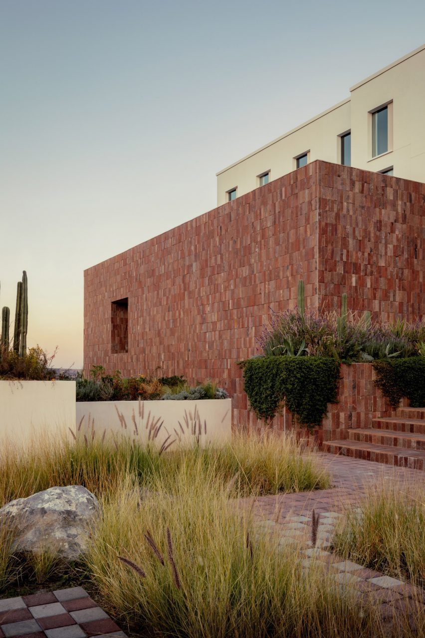 A hotel with stone facade and desert plants