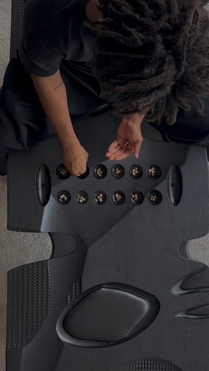 Overhead shot of person playing Oware while sat on a bench