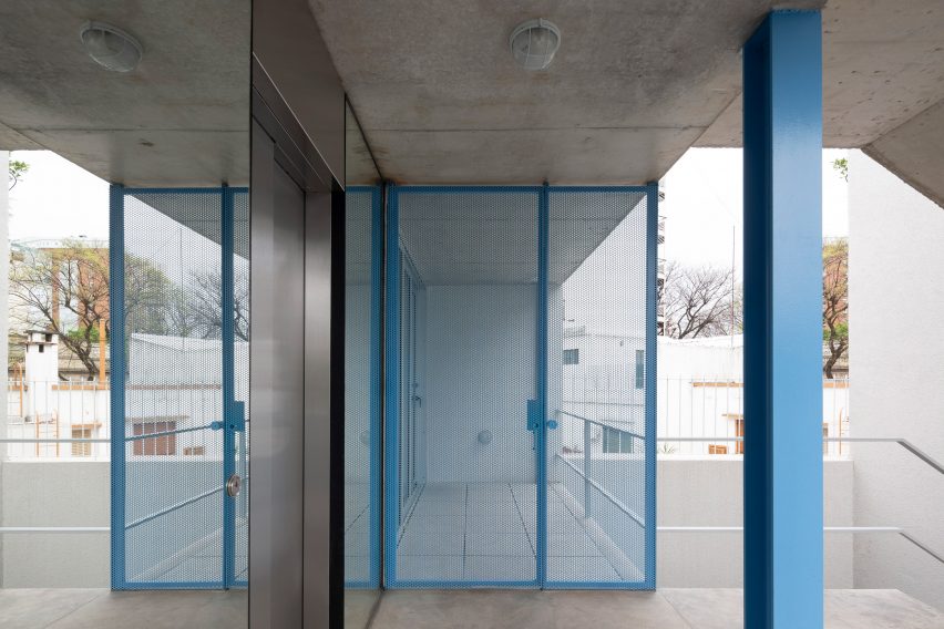 Blue steel column and blue metal mesh gate in a concrete apartment building