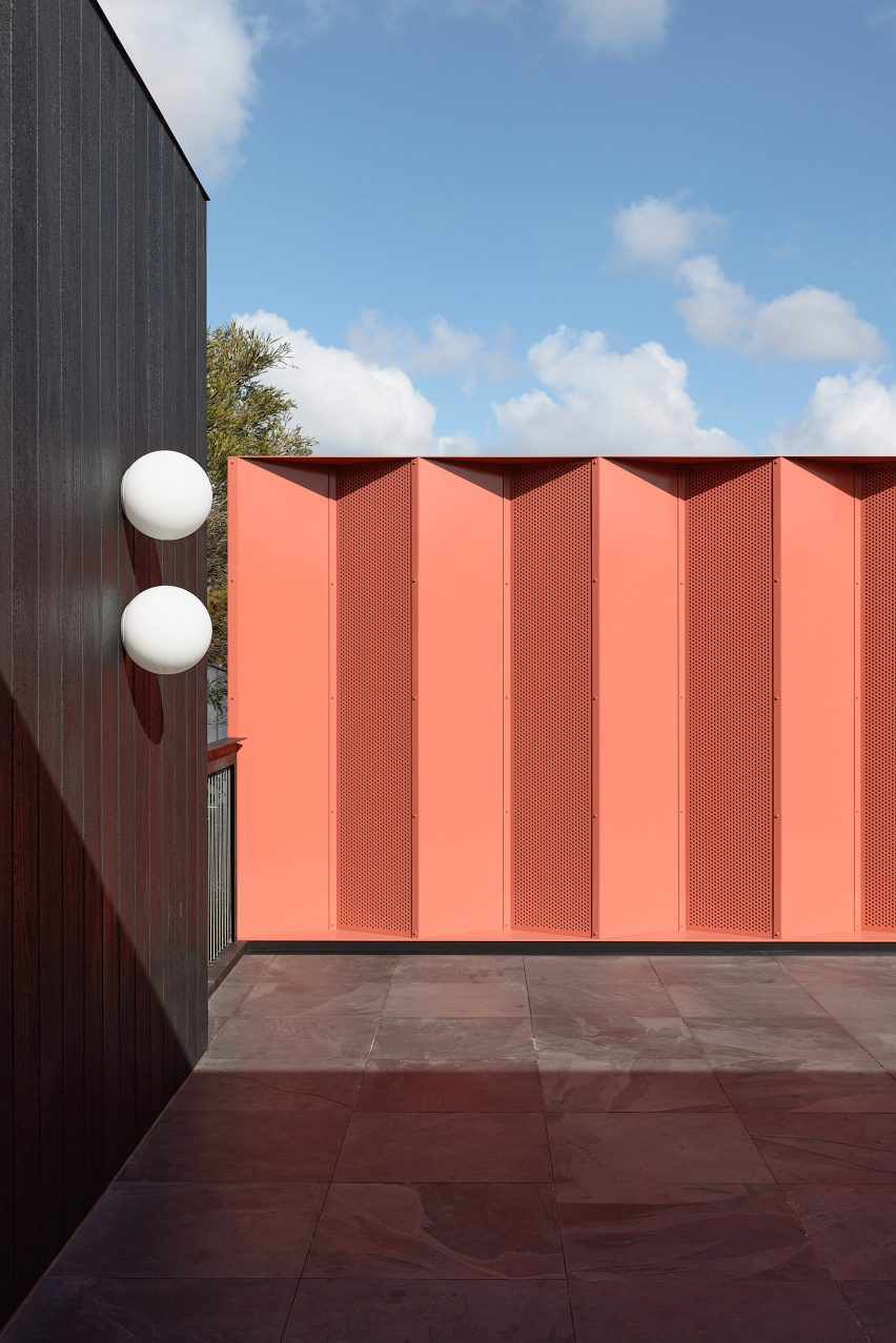 Rood terrace with one black timber wall and a zig-zagging ochre wall