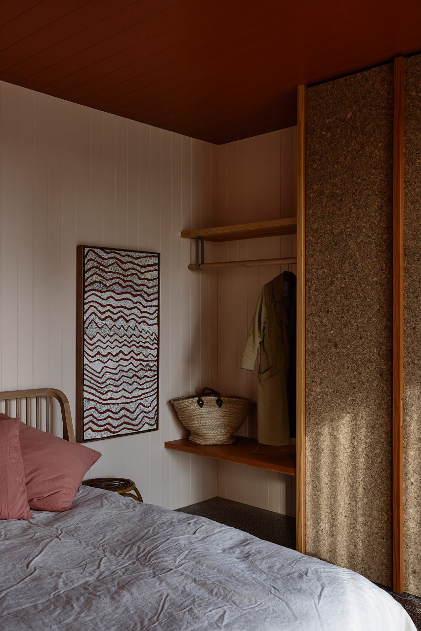 Bedroom with white timber walls and wood shelving