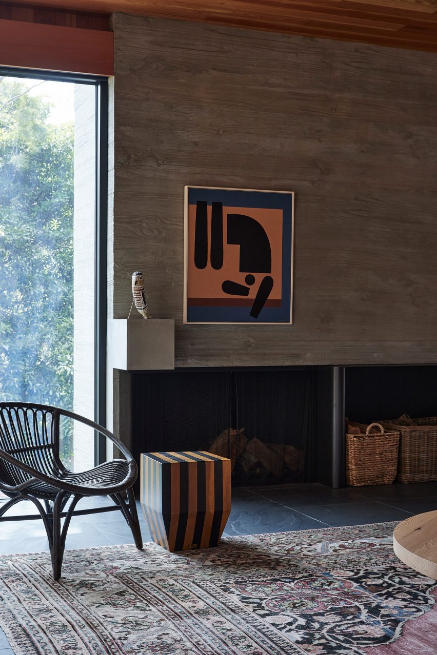 Lounge space with a chair, concrete statement wall and patterned rug
