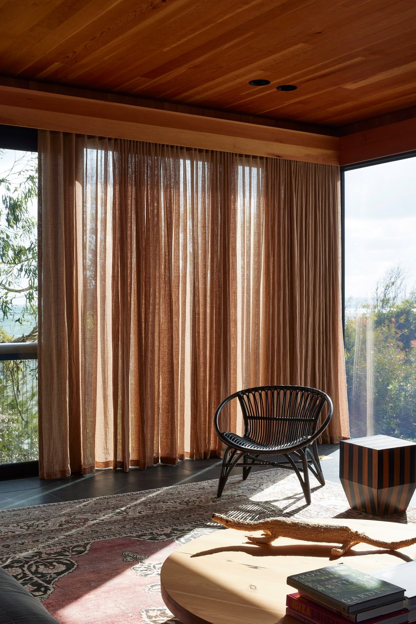 Lounge area with glazed walls, timber sealing and sheer curtains