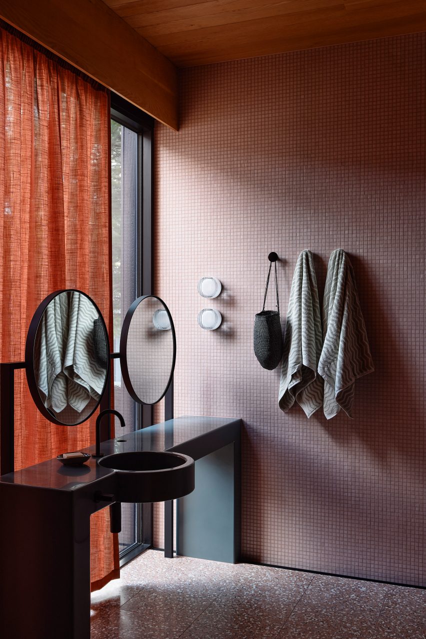 Pink and terracotta-toned bathroom with a black sink