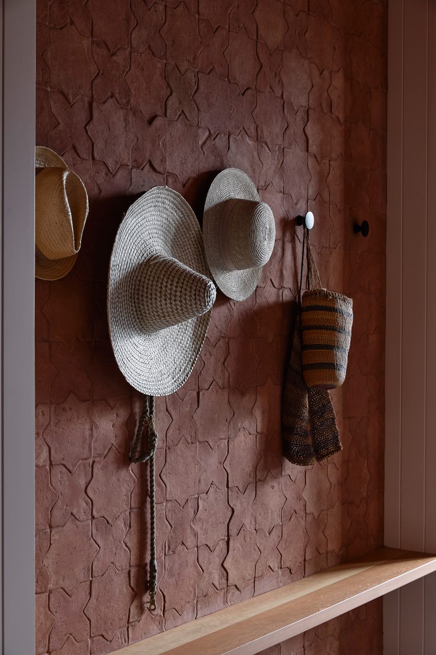 Hats on hooks on a wallpapered wall