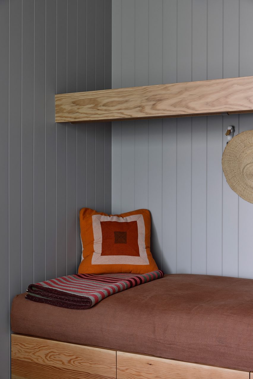 Cushioned seating nook lined with light blue-painted timber