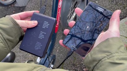 Hands holding a phone that's being charged via a powerbank