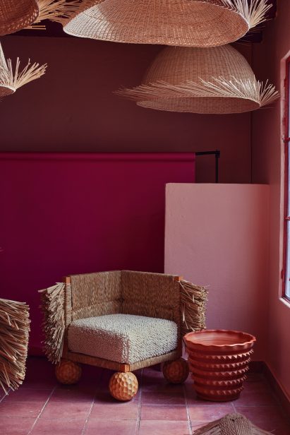 Wicker lights suspended above chairs with tufted sides