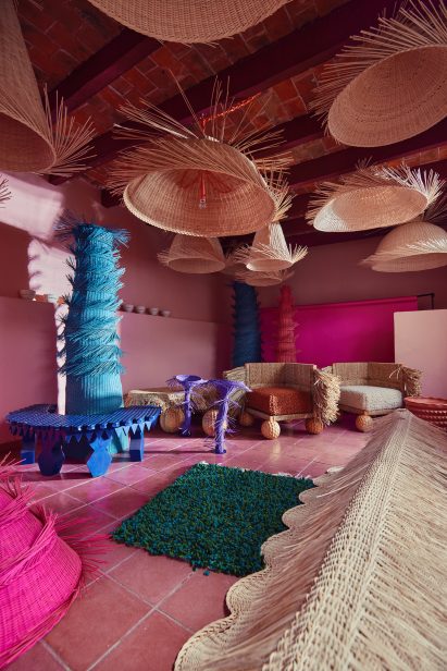 Pink room filled with wicker lighting and furniture