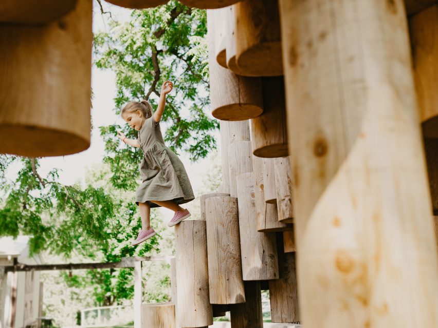 A kid navigating a wooden structure in a playground