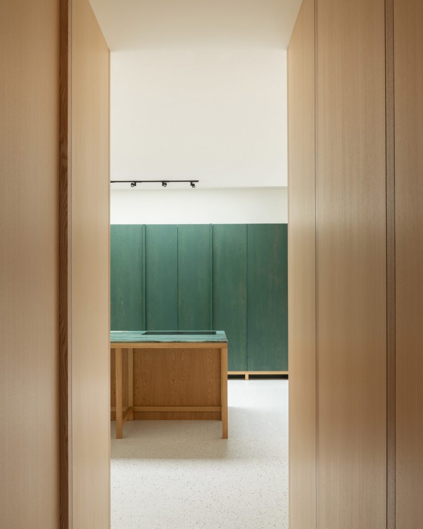 Kitchen with green wall panels and a wood island