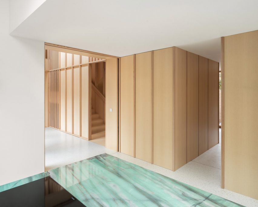 Kitchen with wood wall panelling and a green kitchen island
