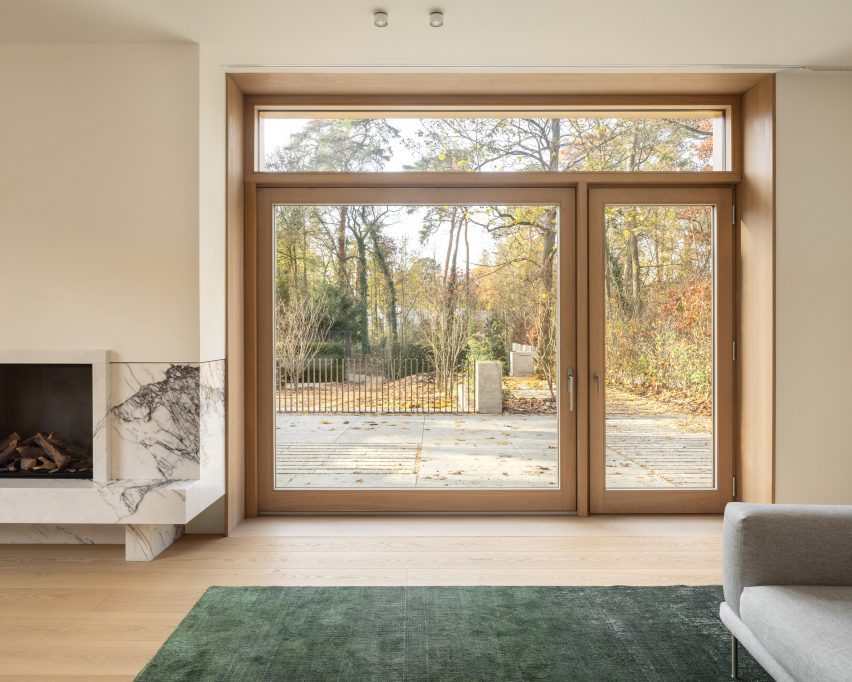 Living room with glass doors leading to a wooded landscape