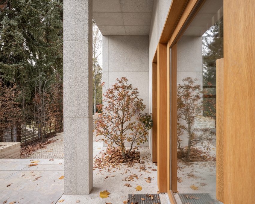 Patio outside a brick and limestone home with wood-framed windows
