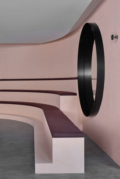 Curved, tiered seating with purple cushions