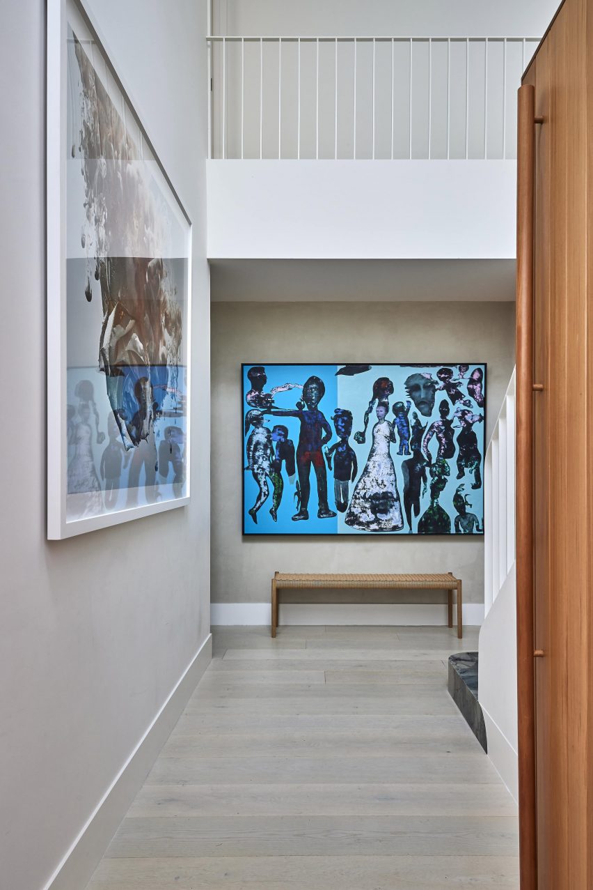 The entrance to a home with a painting with a bright blue background and multiple people