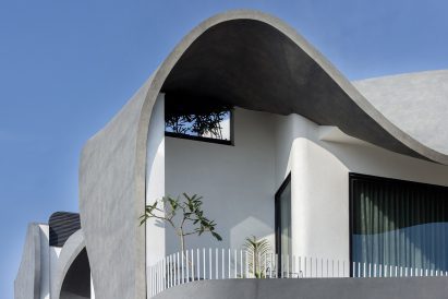 Balcony shaded by sculptural concrete facade