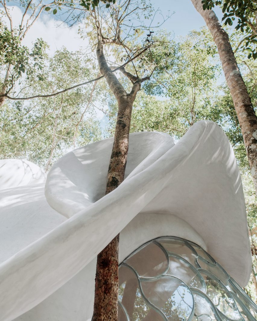 A concrete building that wraps around trees
