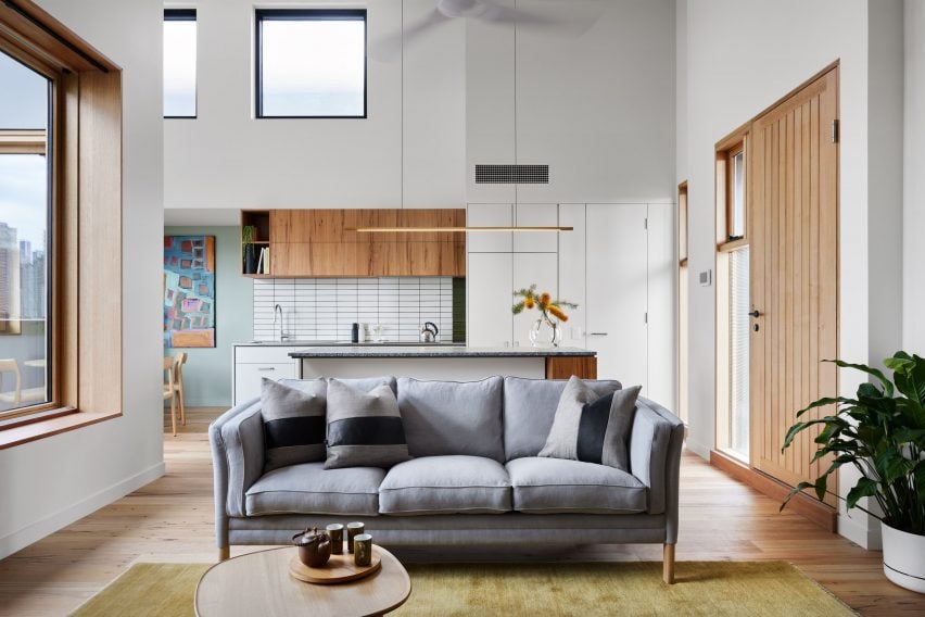 Living room with white walls, wood flooring and a grey sofa