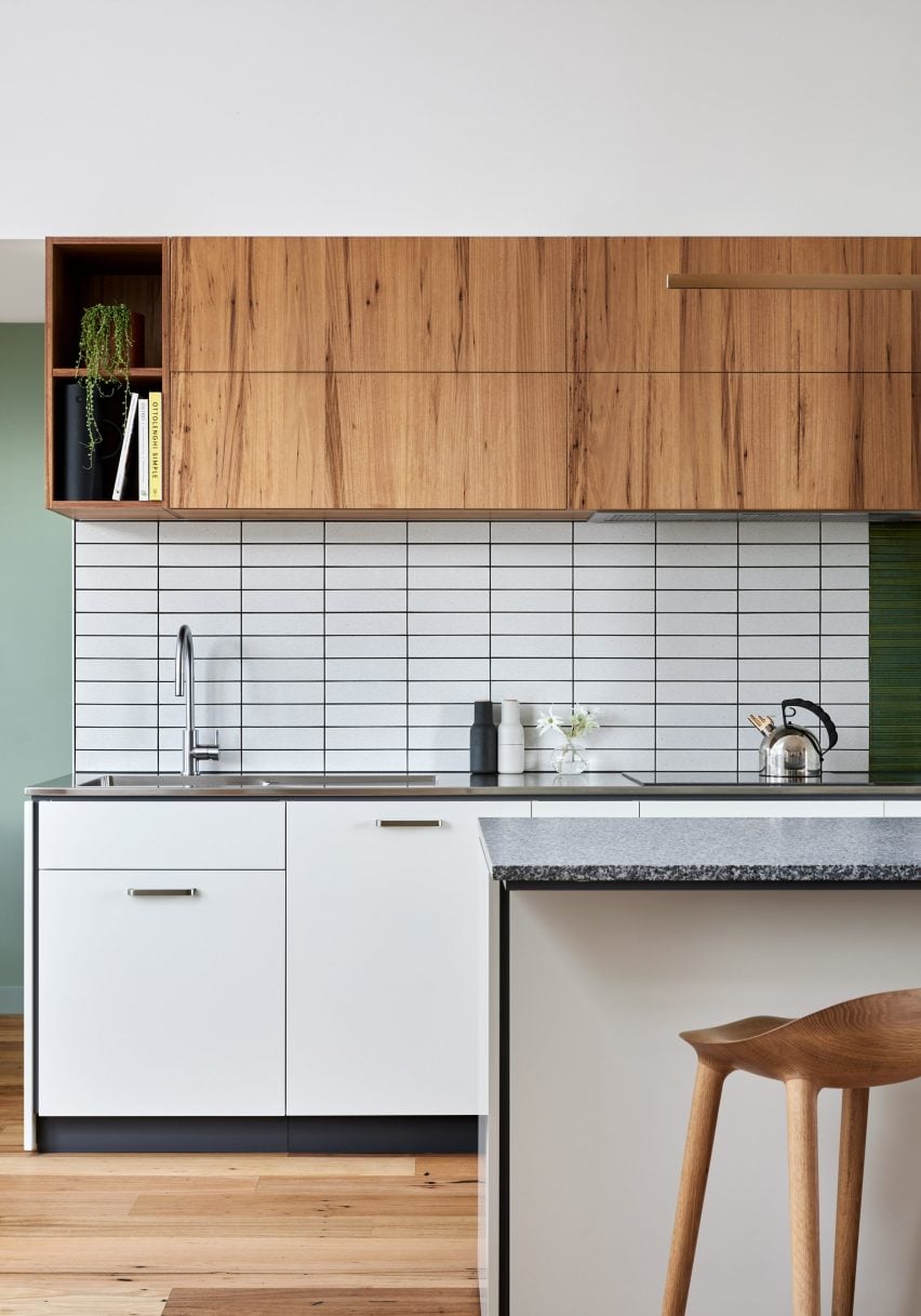 Kitchen with wood top units, white bottom units and white tiled backsplash
