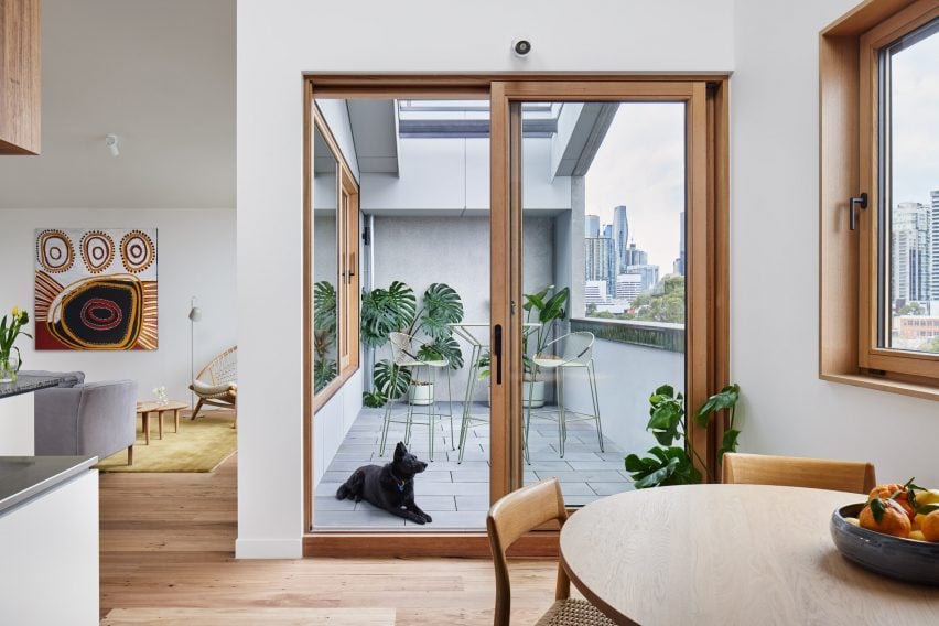 Interior space with wood flooring and glazed doors leading to a balcony