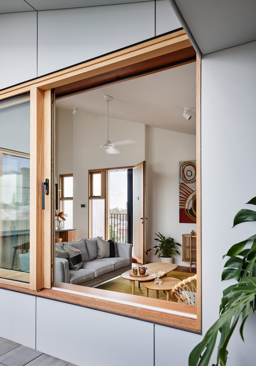 Wood-framed window looking into a living room