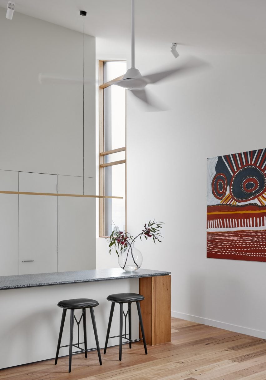 Double0height kitchen with white walls and wood flooring