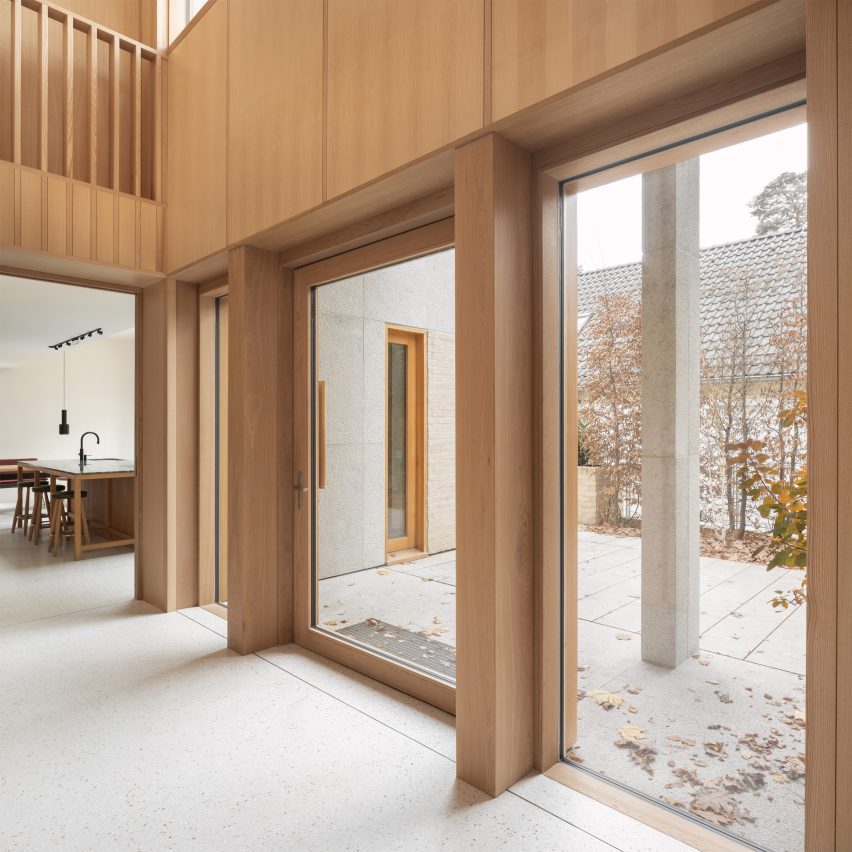 Timber-clad double-height corridor with large windows