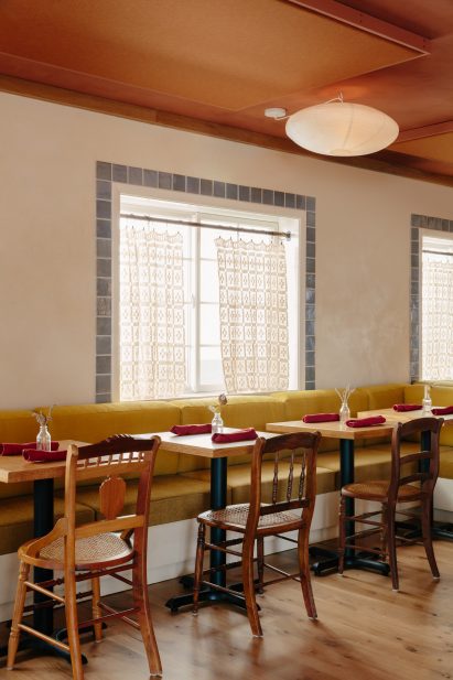 Two-top tables along a bench seat