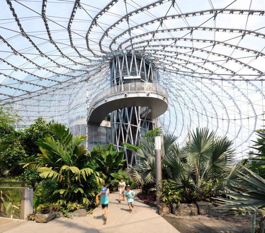 The interior of a building with spiraling cables supporting a translucent roof