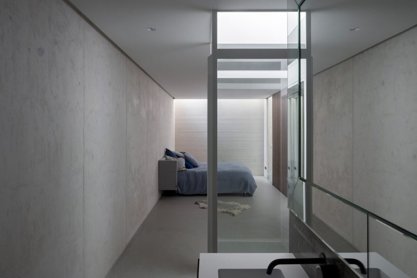 Concrete sunken living room with a glass elevator