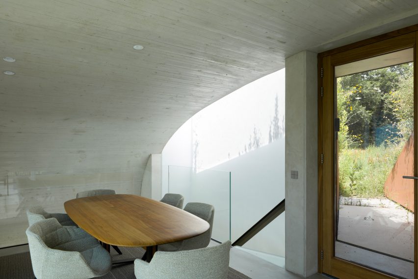 Concrete dining room with curving walls and ceiling
