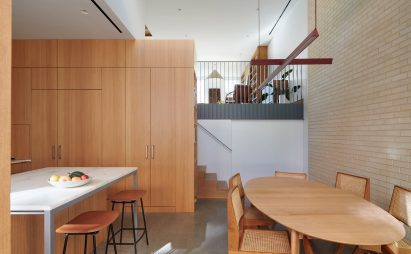 Kitchen and dining area with oak millwork and pale brick wall