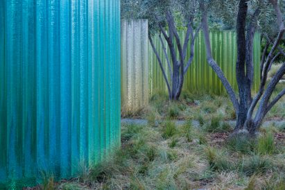 Blue glass cylinders changing to green as they recede into background