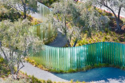 Blue and green glass cylinders in olive grove