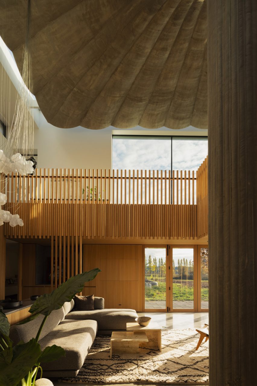A living room with wooden railing and loft