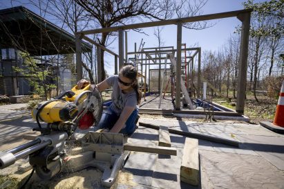 Student cutting wood using a machine