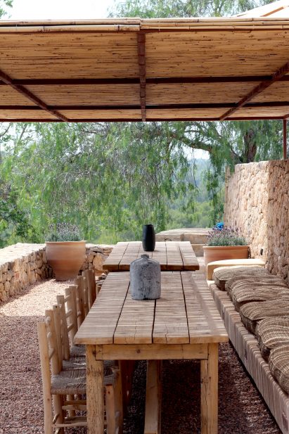 Covered outdoor terrace with wooden dining tables and chairs