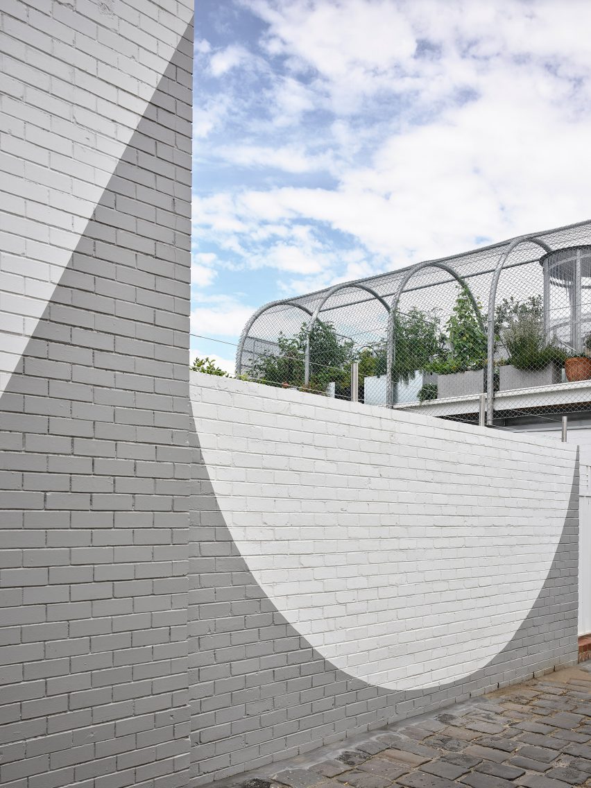 Painted white brick wall and wire mesh surrounding rooftop garden Melbourne