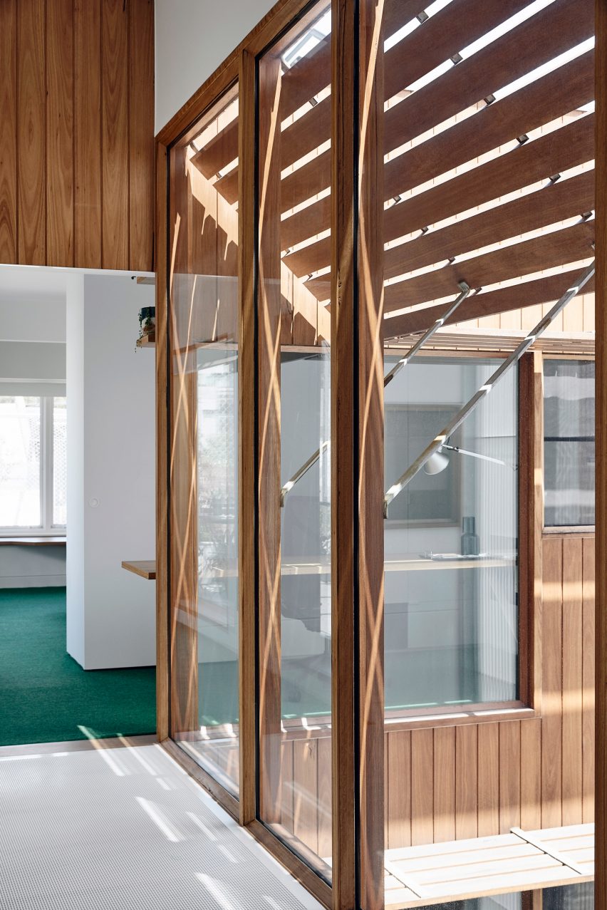 Windows beside metal walkway overlooking atrium in house renovated by Austin Maynard Architects