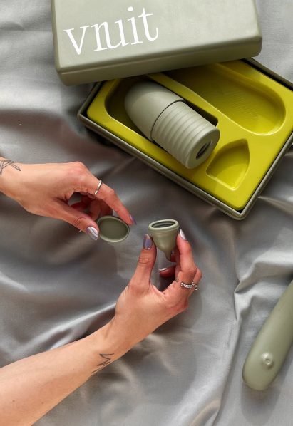Close-up of person holding a menstrual cup with a lid