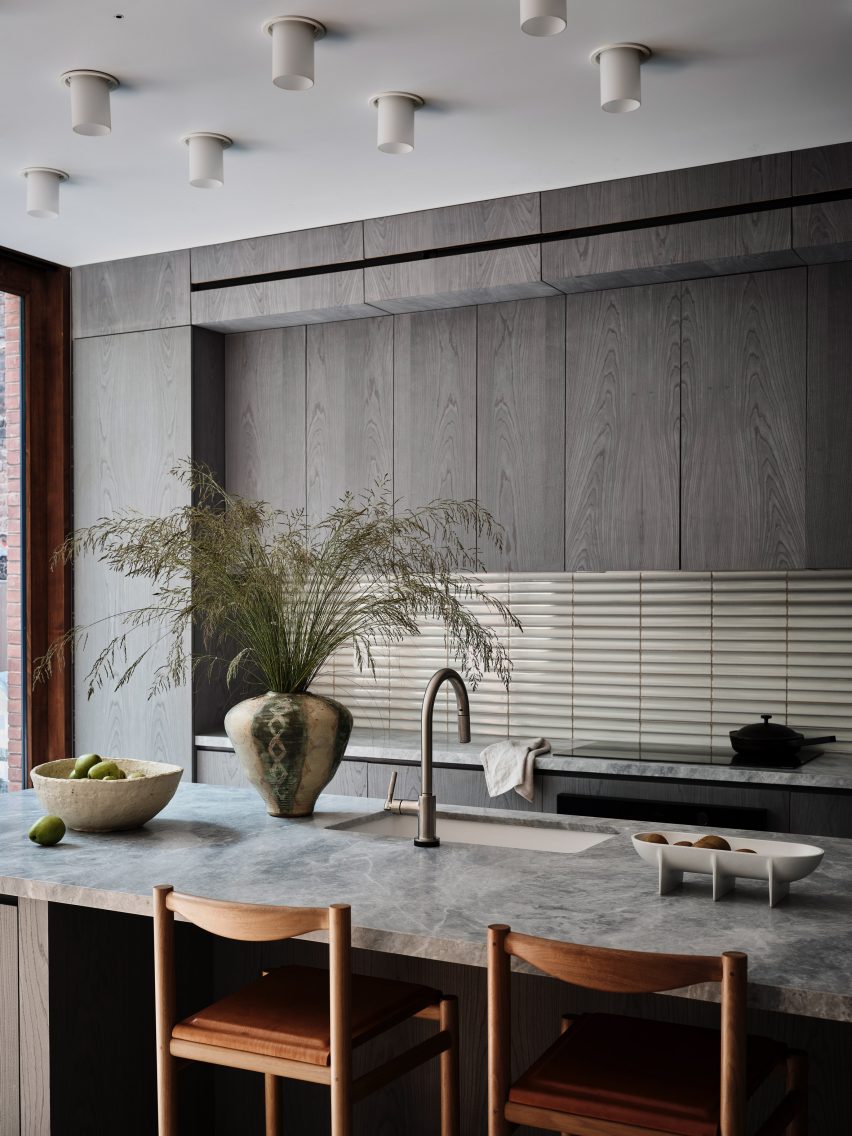 A kitchen with gray cabinetry and large kitchen island