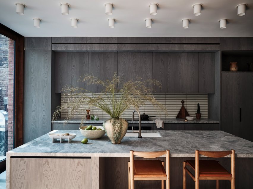 A kitchen with gray cabinetry and large kitchen island