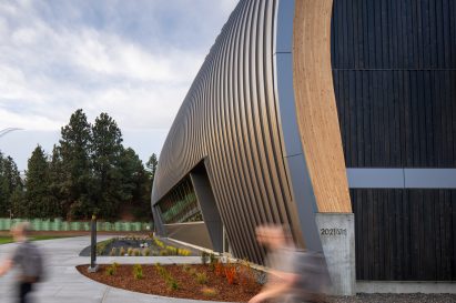 A curving wall with a person walking in front