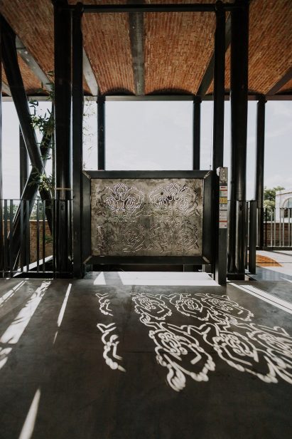 Cutouts in the metal elevator gates cast patterns onto the concrete floor