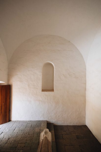 Arched niche within a larger arched, plastered wall