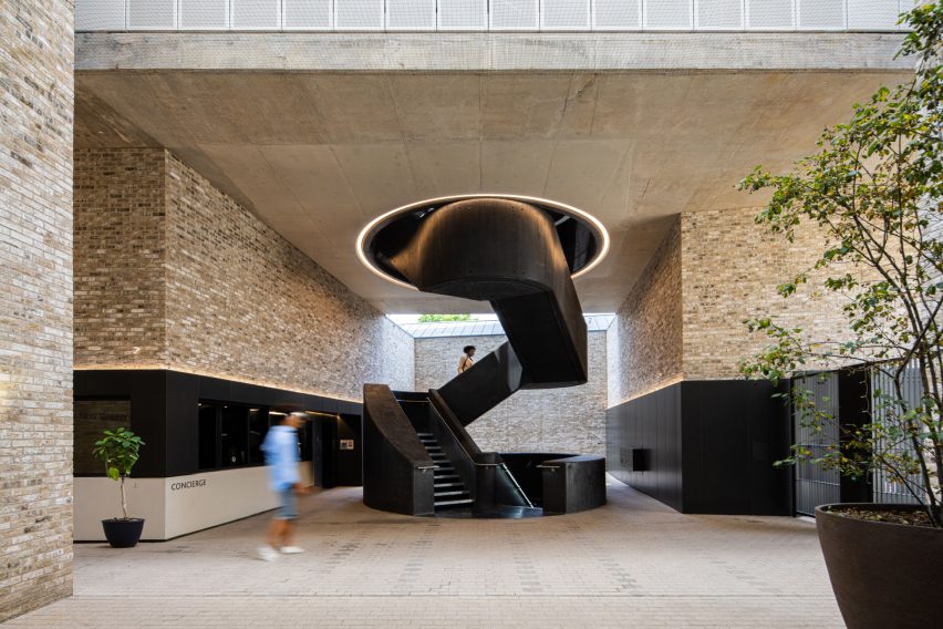 Black spiral staircase by a brick building