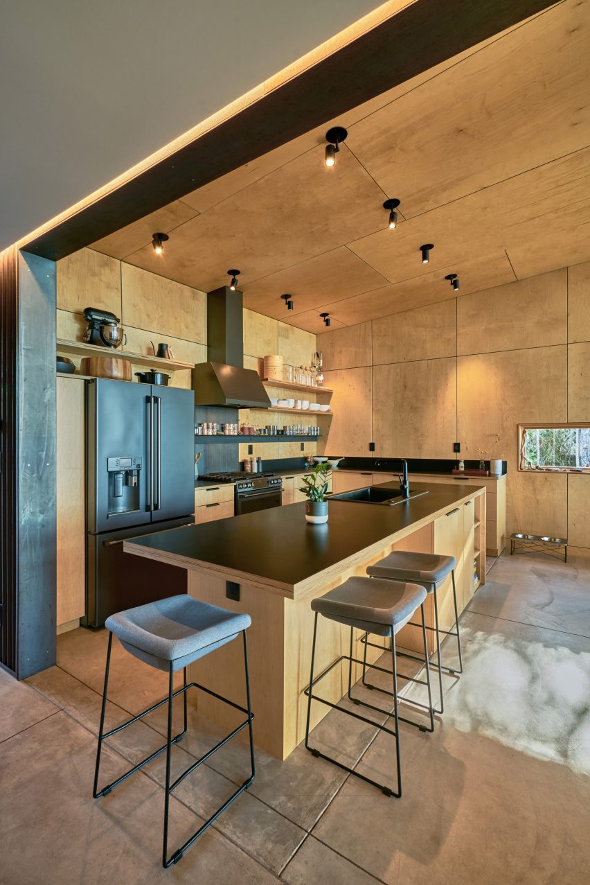 A kitchen with wooden walls and black countertop