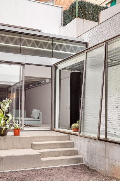 Courtyard with a glass home extension in Barcelona by CRÜ